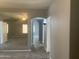 Hallway with tile flooring leading to a carpeted bedroom with a mirrored wall at 35743 W Cartegna Ln, Maricopa, AZ 85138