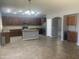 Spacious kitchen with stainless steel appliances, center island with granite countertop, brown cabinets, and tile floors at 35743 W Cartegna Ln, Maricopa, AZ 85138