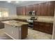 Well-appointed kitchen boasting custom cabinetry, granite countertops, and stainless steel appliances at 35743 W Cartegna Ln, Maricopa, AZ 85138