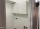 Small laundry room with white walls and upper cabinets at 35743 W Cartegna Ln, Maricopa, AZ 85138