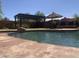 Backyard view showcasing a relaxing pool with pergola and patio umbrella providing ample shade at 35743 W Cartegna Ln, Maricopa, AZ 85138