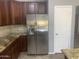 Stainless steel refrigerator with water and ice dispenser, set among brown cabinetry at 35743 W Cartegna Ln, Maricopa, AZ 85138