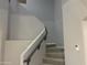 Carpeted staircase with neutral walls, offering a comfortable transition between floors at 35743 W Cartegna Ln, Maricopa, AZ 85138