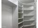 Corner view of walk-in closet with white shelves, rod for hanging clothes, and a door at 35743 W Cartegna Ln, Maricopa, AZ 85138