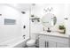 Newly renovated bathroom with white subway tile, updated fixtures, and a stylish vanity with round mirror at 3850 E Ludlow Dr, Phoenix, AZ 85032