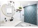 Modern bathroom featuring geometric tile shower, updated fixtures, and a stylish vanity with round mirror at 3850 E Ludlow Dr, Phoenix, AZ 85032