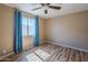 Bedroom with wood flooring and bright blue curtains over the window at 4025 E Surrey Ave, Phoenix, AZ 85032