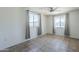 A bright bedroom with tile flooring, a ceiling fan and two windows at 4025 E Surrey Ave, Phoenix, AZ 85032