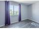 Bedroom with laminate flooring, purple curtains over the window, and light gray walls at 4025 E Surrey Ave, Phoenix, AZ 85032