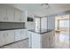 Updated kitchen boasting white cabinets, a functional island, and modern backsplash, ready for cooking at 4025 E Surrey Ave, Phoenix, AZ 85032