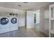 Bright laundry room with tile flooring features a washer and dryer set, and access to the kitchen at 4025 E Surrey Ave, Phoenix, AZ 85032