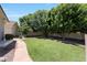 Lush backyard with manicured lawn, mature trees, and stone pathway at 4040 E Mclellan Rd # 16, Mesa, AZ 85205