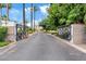 Elegant gated entrance adorned with palm trees and manicured greenery, welcoming residents to a private community at 4040 E Mclellan Rd # 16, Mesa, AZ 85205