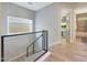 Upstairs hallway featuring wood-look tile, modern railing, and natural light at 4040 E Mclellan Rd # 16, Mesa, AZ 85205