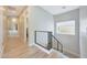 Bright hallway with wood-look tile flooring and a modern cable railing staircase at 4040 E Mclellan Rd # 16, Mesa, AZ 85205