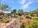 Beautiful desert landscaped backyard with cacti, bushes, boulders, and a tranquil water feature at 41318 N Belfair Way, Anthem, AZ 85086