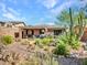 Lush backyard featuring a cozy covered patio and colorful desert landscaping for relaxation at 41318 N Belfair Way, Anthem, AZ 85086