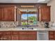 Gourmet kitchen with a sink overlooking a serene outdoor seating area at 41318 N Belfair Way, Anthem, AZ 85086