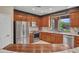 Well-equipped kitchen featuring stainless steel appliances, granite countertops, and wooden cabinetry at 41318 N Belfair Way, Anthem, AZ 85086