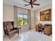 Cozy living room with vintage leather chair, writing desk, and garden view through a large bright window at 41318 N Belfair Way, Anthem, AZ 85086