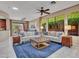 Spacious living room with large windows, plush sofas, and direct access to outdoor patio at 41318 N Belfair Way, Anthem, AZ 85086