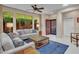 Bright living room with large windows, plush seating, and a decorative area rug at 41318 N Belfair Way, Anthem, AZ 85086