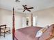 Spacious main bedroom with a four-poster bed, neutral walls, and access to the laundry room at 41318 N Belfair Way, Anthem, AZ 85086
