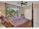 Four-poster bed in the main bedroom, with a view of the landscaped backyard through a large window at 41318 N Belfair Way, Anthem, AZ 85086
