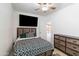 Bedroom with ceiling fan and a large bed, features a wooden dresser and a mounted flat screen TV at 43525 W Cydnee Dr, Maricopa, AZ 85138