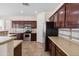 Functional kitchen with stainless steel appliances and ample dark-stained wood cabinetry at 43525 W Cydnee Dr, Maricopa, AZ 85138