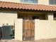 Private backyard area featuring a wooden gate, stucco walls, and a tile roof for outdoor enjoyment at 455 S Mesa Dr # 104, Mesa, AZ 85210