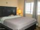 Bedroom features a large bed with a black headboard, soft carpet, and large window at 455 S Mesa Dr # 104, Mesa, AZ 85210