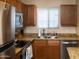 Updated kitchen features granite countertops, stainless steel appliances, wood cabinets, and natural light at 455 S Mesa Dr # 104, Mesa, AZ 85210