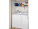 Bright laundry area with white washer and dryer, and shelves at 455 S Mesa Dr # 104, Mesa, AZ 85210