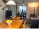 Living room with bright light, fan, couch and an adjacent wooden table staged with fruit at 455 S Mesa Dr # 104, Mesa, AZ 85210