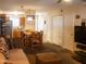 A staged living room with hardwood dining table, carpet, neutral walls, and a view into the kitchen at 455 S Mesa Dr # 104, Mesa, AZ 85210
