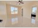 Bright bedroom featuring neutral walls, ceiling fan, and sleek tile flooring with a view of the backyard at 461 W Lindbergh Ave, Coolidge, AZ 85128