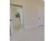 Hallway with neutral colored walls and sleek tile flooring leading to a bright kitchen with modern stainless appliances at 461 W Lindbergh Ave, Coolidge, AZ 85128