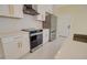 Modern kitchen featuring white cabinets, stainless steel appliances, and a sleek oven at 461 W Lindbergh Ave, Coolidge, AZ 85128