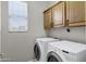 Bright laundry room with a washer, dryer, and upper cabinets at 4777 S Fulton Ranch Blvd # 2071, Chandler, AZ 85248