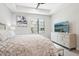 Well-lit bedroom with a ceiling fan, large window, and dresser with television at 5250 E Deer Valley Dr # 247, Phoenix, AZ 85054