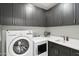 Well-organized laundry room featuring a washing machine, dryer, sink, and ample cabinet space at 5250 E Deer Valley Dr # 247, Phoenix, AZ 85054