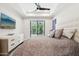 Relaxing main bedroom featuring a tray ceiling, ceiling fan, and sliding door access to outdoor balcony at 5250 E Deer Valley Dr # 247, Phoenix, AZ 85054