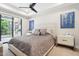 Comfortable main bedroom with sliding glass doors, neutral tones, ceiling fan, and elegant furnishings at 5250 E Deer Valley Dr # 247, Phoenix, AZ 85054