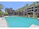 Resort-style pool with palm trees and lounge chairs in a modern apartment complex at 5250 E Deer Valley Dr # 247, Phoenix, AZ 85054
