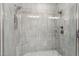 Modern shower with a glass enclosure, stone tile, and dual shower heads at 5250 E Deer Valley Dr # 247, Phoenix, AZ 85054