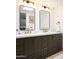 Modern bathroom featuring a double vanity with sleek gray cabinets, gold fixtures, and stylish black framed mirrors at 6835 E Friess Dr, Scottsdale, AZ 85254