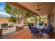 Spacious backyard patio with comfortable seating, lush trees, and view of swimming pool at 6862 W Honeysuckle Dr, Peoria, AZ 85383