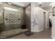 Luxurious bathroom featuring a spacious walk-in shower with pebble floor, modern tile design, and bench seating at 6862 W Honeysuckle Dr, Peoria, AZ 85383