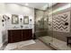 Spa-like bathroom featuring a double vanity, large walk-in shower with pebble floor, and herringbone tile at 6862 W Honeysuckle Dr, Peoria, AZ 85383